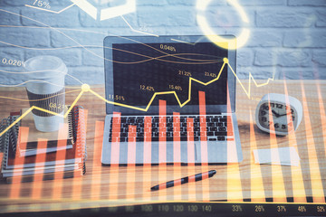 Double exposure of graph and financial info and work space with computer background. Concept of international online trading.