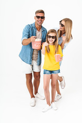 Wall Mural - Photo of happy family in 3D glasses holding popcorn bucket while watching movie in cinema