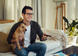 © StratfordProductions - Smiling man sitting with his dog watching the television at home