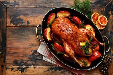 Canvas Print - Roast goose stuffed with baked apples in a skillet, festive christmas recipe. Top view with copy space.