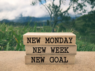 Wall Mural - Motivational and inspirational wording - New Monday, New Week, New Goal written on wooden blocks. Blurred styled background.