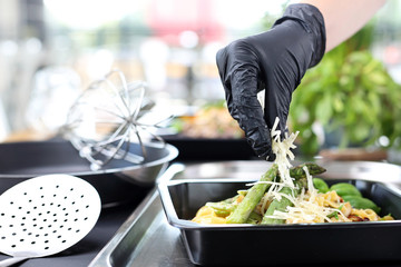 The cook prepares food. Pasta with asparagus. Take-out dish