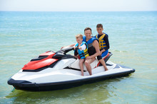 FAMILY FATHER WITH SONS ON A HYDROCYCLE IN THE SEA
