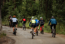 Group Of Cyclists Men And Women Riding On Forest Trail Mountain Bike