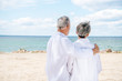 © LIGHTFIELD STUDIOS - back view of senior couple in white shirts embracing at beach