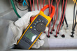 Workers use clamp meter to measure the current of electrical wires produced from solar energy for confirm to normal current