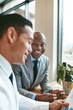 © Flamingo Images - Smiling African American businessman working with a colleague