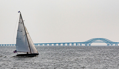 Sailboat sailing toward bridge in the Great South Bay Babylon