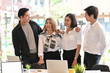 © Prathankarnpap - Business together, Four young business people confidently and motivation relax in modern office.