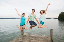 Germany, Bavaria, Starnberger See, Young People Jumping On Jetty, Laughing, Portrait