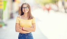 Young Girl With Glasses Standing In Somewhere The City Smiling And Looking At The Camera