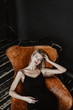 © Alina Hvostikova/Stocksy - Elegant woman in gorgeous armchair