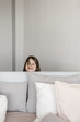 © Alina Hvostikova/Stocksy - Little girl peeking out bed headboard