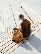 Woman With Backpack And Studies On Bench