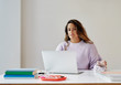 © W2 Photography/Stocksy - Portrait of a young professional woman sitting at a desk in her home office.