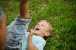 © Pietro Karras/Stocksy - Laughing boy lying on green grass