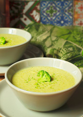 Fresh Broccoli cream soup on two gray ceramic bowl on plate with spoon on marble background,vegetarian food,healthy concept