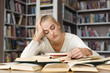 © Prostock-studio - Fatigued blondy girl reading book in library