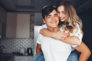 Loving couple have fun at home. Pretty blonde in a white blouse.