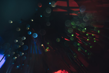 Poster - Beautiful multi-colored abstract optical fiber line on a red bokeh background.