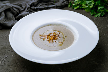 Wall Mural - Cream soup of mushrooms on black concrete table