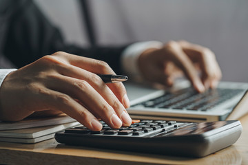 Close up businessman hand using calculator and laptop in office.finance concept