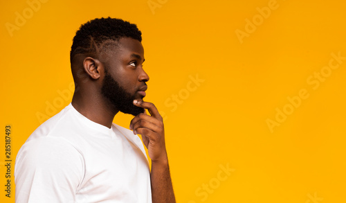 Fotomural Profile portrait of thoughtful african man on yellow studio background