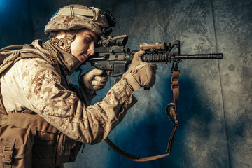 Wall Mural - American private military contractor shooting a rifle. Studio shot