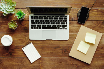 Poster - Office table workspace top view. Wooden desk with laptop, devices and plant