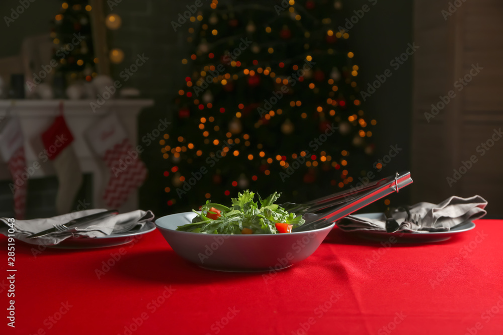 Bowl with tasty arugula salad on table