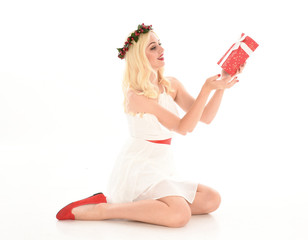 Poster - full length portrait of blonde girl wearing a white dress and flower crown.  Sitting pose, holding red present, isolated against a  white studio background.