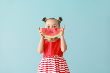 Poster - Cute little girl with slice of fresh watermelon on color background