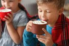 Cute Little Boy Drinking Hot Chocolate At Home On Christmas Eve