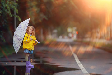 little girl with an umbrella / small child, rainy autumn walk, wet weather child with an umbrella