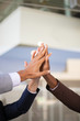 © Mangostar - United business team celebrating success and joining hands. Group of three businesspeople giving high five to each other. Teambuilding concept