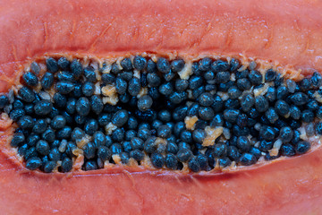 Half of ripe sweet papaya fruit with seeds background, closeup