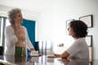 © Mangostar - Serious mother and daughter talking at home. Side view of senior mother and middle aged daughter spending time together and looking at each other. Family concept