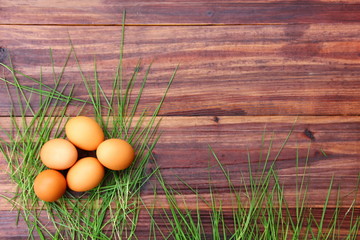 topview organic eggs with grass on retro wood background,copyspace