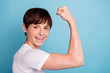 © deagreez - Photo of cheerful funny positive boy pushing his arm muscles while isolated with blue background