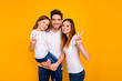 © deagreez - Portrait of three nice attractive charming cute lovely sweet tender cheerful cheery optimistic person showing v-sign enjoying leisure isolated over bright vivid shine yellow background
