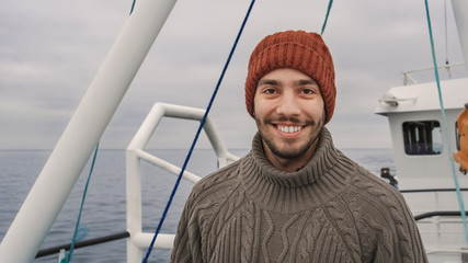 Wall Mural - Portrait of Casualy Dressed Smiling Fisherman on Commercial Fishing Boat.