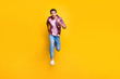 © deagreez - Full length body size photo of serious running man looking at camera moving towards it while isolated with yellow background