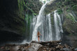Air Terjun Tiu Kelep waterfall near Rinjani, Senaru, Lombok, Indonesia, Southeast Asia. Back view young woman in bikini look on  beautifull waterfal, tiu kelep waterfall lombok