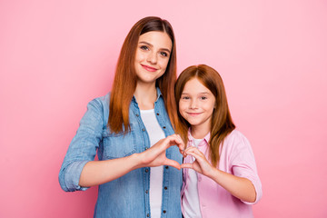 Sticker - Pretty foxy small lady and her mom making heart figure with hands wear casual clothes isolated pink background