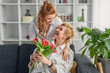 © kegfire - Daughter giving flowers to excited mother