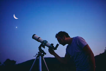 Wall Mural - astronomer with a telescope watching at the stars and moon. my astronomy work.