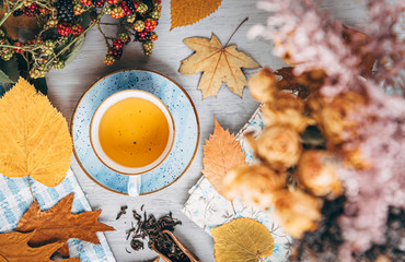 Wall Mural - autumn warming tea on a wooden table with autumn tree leaves lying nearby