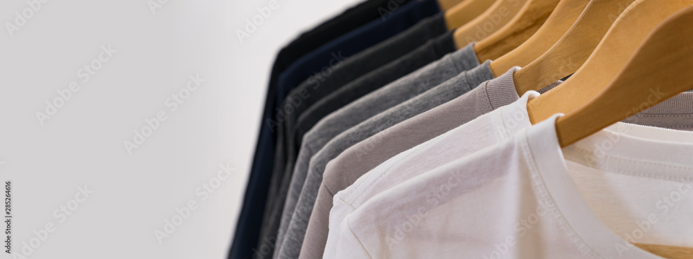 Close up of T-shirts on hangers, apparel background - obrazy, fototapety, plakaty 