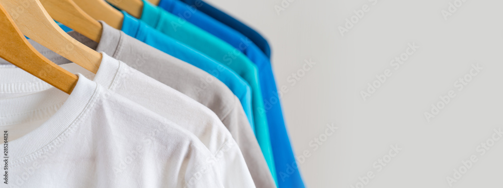 Close up of Colorful t-shirts on hangers, apparel background - obrazy, fototapety, plakaty 