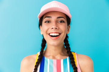 Poster - Image of cheerful brunette girl wearing summer dress and cap smiling at camera